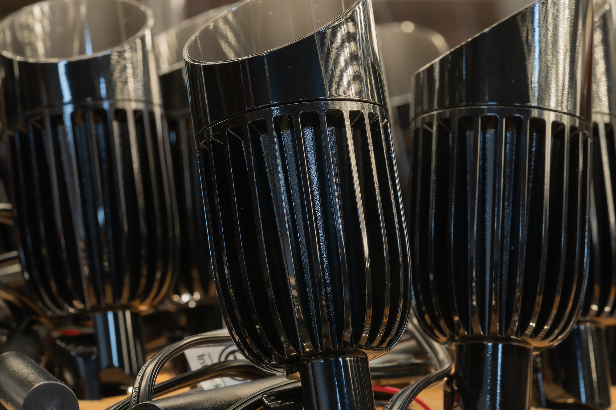 Black V3 Spotlight fixtures in production showing the vertical heat-sink finning
