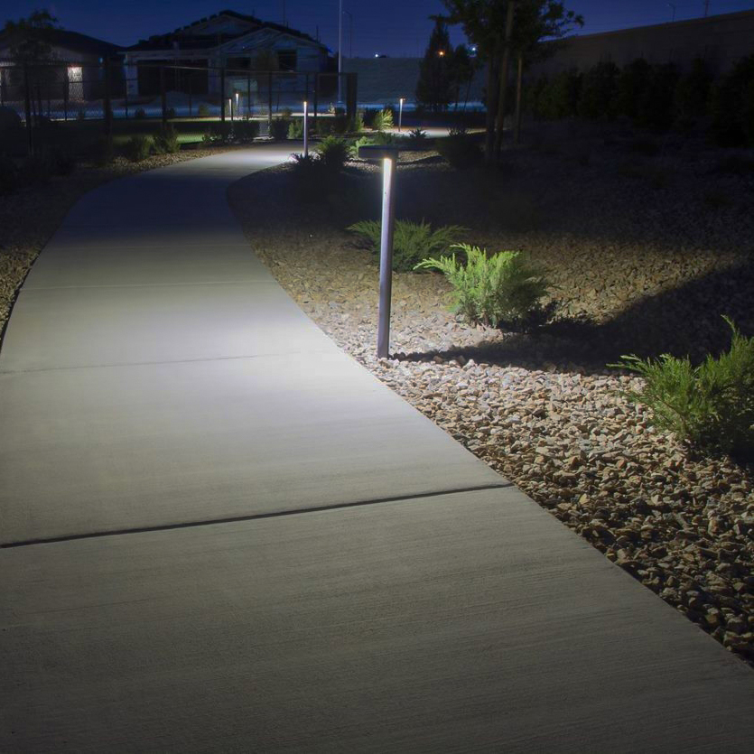P11 Path Light illuminating a commercial walkway at twilight